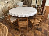 une table recouverte d'une nappe blanche, entourée de six chaises