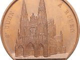 a bronze coin with a picture of a cathedral on it