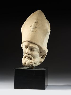 a white marble head of a man wearing a hat