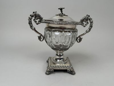 an antique silver plated sugar dish with a lid on a stand