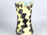 un vase jaune orné de motifs noirs et blancs