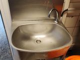 a stainless steel sink in the corner of a kitchen