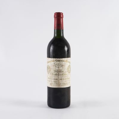 une bouteille de vin rouge posée sur une table blanche