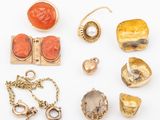 an assortment of gold and coral jewelry on a white surface