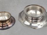 a silver candle holder and a silver candle holder on a table