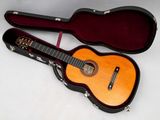 une image représentant une guitare dans un étui, posée sur une surface blanche