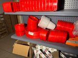 a shelf with many different types of red plastic pipes