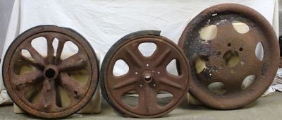 three old wheels are sitting on a table in front of a white cloth