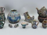 many pieces of pottery that are sitting on a table