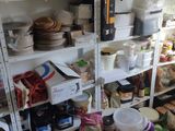 des étagères remplies de provisions et de produits d'épicerie dans une cuisine au sol en damier