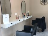 une photo d'un salon de coiffure avec des fauteuils et des miroirs