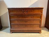 a wooden chest of drawers with a marble top