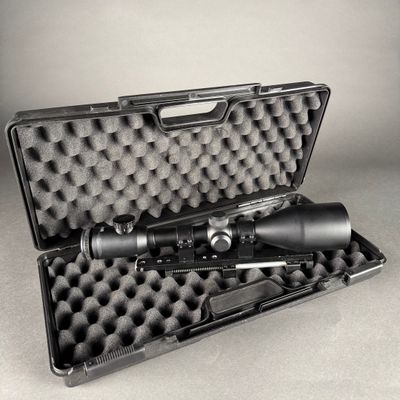 an open case with a rifle and a scope on a table