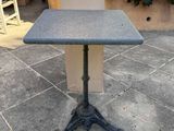 an outdoor table sitting on a patio next to a chair