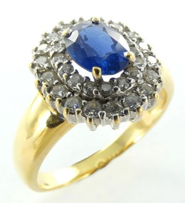 gros plan d'une bague avec une pierre bleue entourée de diamants