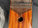 a small wooden musical instrument on a table next to a bag