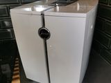 a white refrigerator sitting on top of a counter in a kitchen