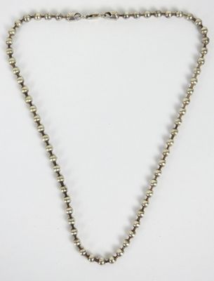 a close up of a necklace on a white surface