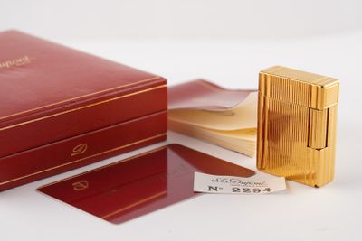 une boîte rouge avec un briquet doré à côté