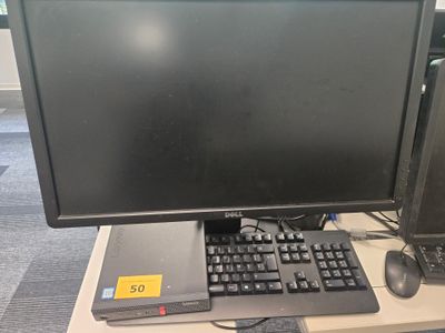 un écran d'ordinateur et un clavier posés sur un bureau
