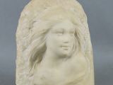 une image représentant une sculpture représentant la tête d'une femme posée sur un rocher