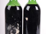 deux bouteilles de vin sont posées l'une à côté de l'autre sur une surface blanche