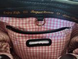 a black purse with a pink and white checkered pattern