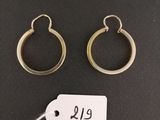 deux boucles d'oreilles en anneau dorées et une étiquette de prix sur fond noir