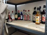 many bottles of alcohol sitting on a shelf in a room