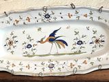 un grand plat sur lequel est posé un oiseau, posé sur une table