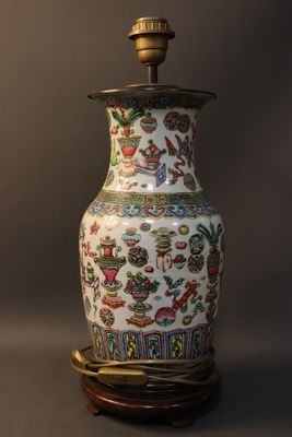 a vase on a stand with a lamp on top of it