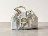 un sac à main blanc posé sur une table près d'un mur blanc