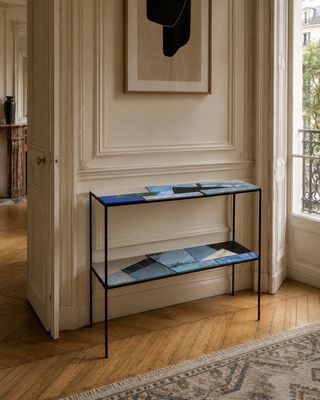 une photo d'un salon avec une table et une lampe