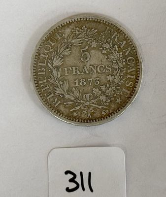 gros plan d'une pièce de monnaie sur une surface blanche avec une étiquette