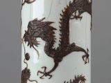 un vase orné d'un motif de dragon, posé sur une table