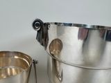 a silver ice bucket and a silver cup on a table