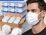 un homme portant un masque à côté d'une boîte de masques