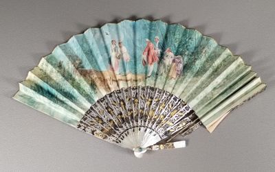 a fan with a painting on it hanging on the wall