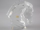 sculpture en verre transparent représentant une tête de cheval sur fond blanc