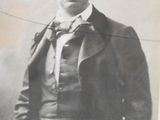 a black and white photo of a man in a suit and tie
