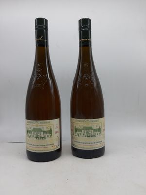 deux bouteilles de vin posées l'une à côté de l'autre sur une surface blanche