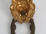 a gold lion head ring on a white surface