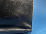 a close up of a black leather purse on a blue background