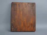an old wooden cutting board on a gray surface