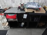 une armoire noire sur laquelle sont posés tout un tas d'objets