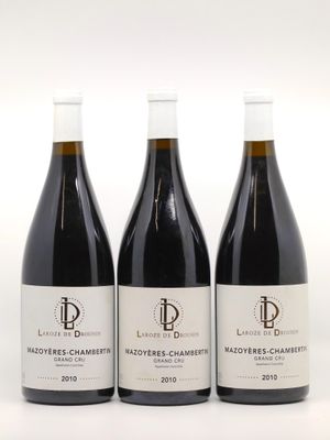 trois bouteilles de vin rouge posées sur une table blanche