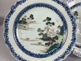 two blue and white plates with flowers on them sitting on a table