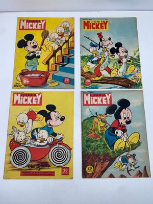 Trois bandes dessinées de Mickey sont exposées sur une table