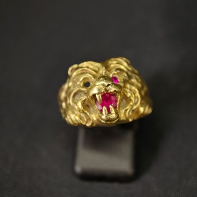 Gros plan sur une bague en or ornée d'une pierre rouge
