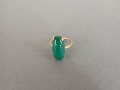 Gros plan sur une bague ornée d'une pierre verte